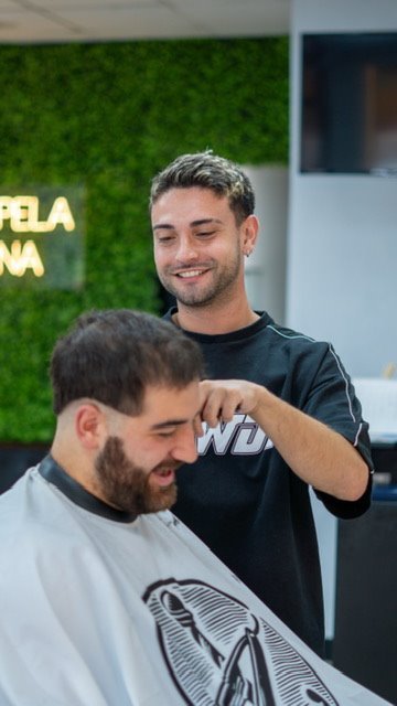 Samuel, fundador de Lorenzo's Barber Studio, atendiendo a un cliente